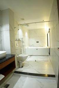Un baño con lavabo, inodoro y bañera. en The Royal Velvet Hotel & Resort, en Rohtak 26 fotos más