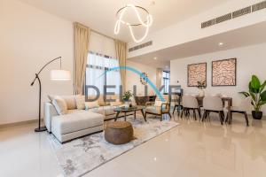 a living room with a couch and a table at Special Rate with Temp Controlled Pool, BBQ & Maid's by Deluxe Holiday Homes in Fujairah