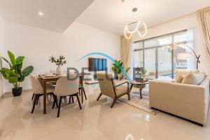 a dining room and living room with a table and chairs at Special Rate with Temp Controlled Pool, BBQ & Maid's by Deluxe Holiday Homes in Fujairah