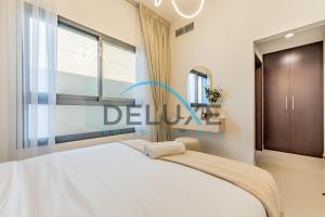 a bedroom with a white bed and a window at Special Rate with Temp Controlled Pool, BBQ & Maid's by Deluxe Holiday Homes in Fujairah