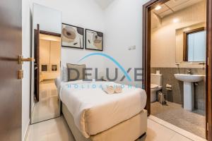 a bedroom with a bed and a bathroom at Special Rate with Temp Controlled Pool, BBQ & Maid's by Deluxe Holiday Homes in Fujairah