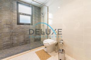 a bathroom with a shower and a toilet at Special Rate with Temp Controlled Pool, BBQ & Maid's by Deluxe Holiday Homes in Fujairah