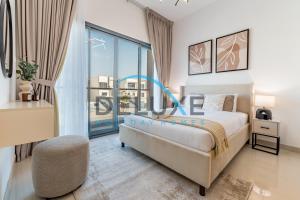 a bedroom with a bed and a large window at Special Rate with Temp Controlled Pool, BBQ & Maid's by Deluxe Holiday Homes in Fujairah