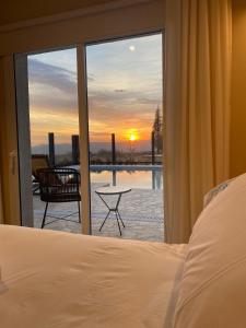 a bedroom with a bed and a view of the sunset at TERMAS PISMANTA Hotel & Spa in Las Flores