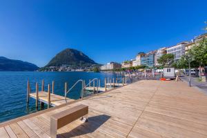 a wooden dock with a bench next to the water at Novos Contrada in Lugano