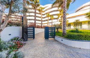 a courtyard with palm trees and a building at Durres Currila Beach RESORT White Hill in Durrës
