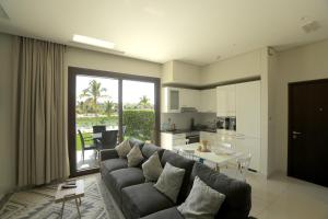 Una sala de estar con un sofá y una mesa y una cocina. en Luxury Redefined in Hawana Salalah, en Salalah