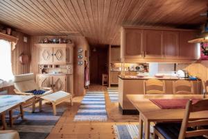 eine Küche mit Holzschränken und einem Tisch und Stühlen in der Unterkunft Trysilfjellet Nord 607 in Trysil