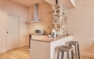a kitchen with two bar stools and a microwave at Awesome Apartment In Cádiz With Kitchen in Cádiz