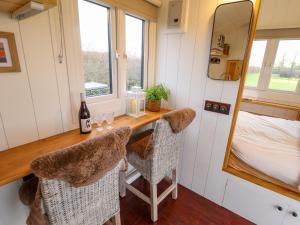 a tiny house with a desk and a mirror at Shepherds Hut - Oak in Lincoln