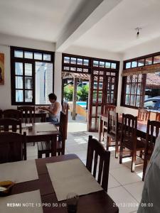 uma pessoa sentada numa mesa num restaurante em Pousada Flor do Dendê em Arraial d'Ajuda