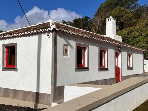a small white house with a red door at Casa do Postigo Rustic Refuge to Relax in Angra do Heroísmo