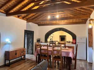 a dining room with a table and a kitchen with an archway at Casa do Postigo Rustic Refuge to Relax in Angra do Heroísmo
