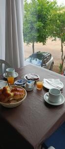 a table with a breakfast of pancakes and orange juice at Hospedaje Familia Puma in Valeria del Mar