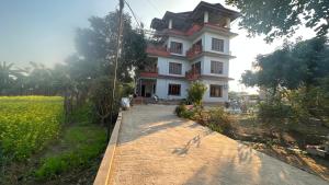 NārāyangarhChitwan Comforts Apt 2的田野前的路上的房子