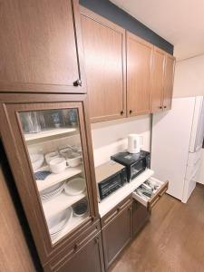 a kitchen with an open cabinet filled with dishes at Chalet 広島 120square japanese one story house 13mins walk from 広島Station in Hiroshima +15 photos