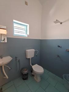 un bagno con un water e un lavandino di Yog Hostel Varkala a Varkala