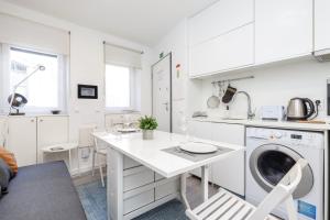 una cocina blanca con una lavadora dentro en GuestReady - Minimalist Studio In Downtown Lisbon, en Lisboa