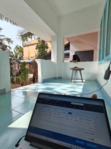 un computer portatile seduto su un tavolo in una casa di Yog Hostel Varkala a Varkala Altre 17 foto
