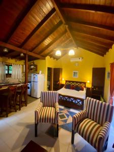 a bedroom with a bed and two chairs and a kitchen at El Quincho in Costa del Este