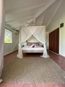Cama en habitación con techo en Villa Magalante, sea view, en Grand-Bourg 31 fotos más