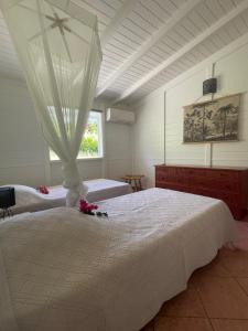 1 dormitorio con 2 camas con flores en Villa Magalante, sea view, en Grand-Bourg