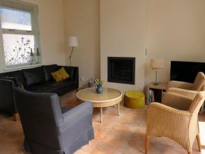 una sala de estar con un sofá y una mesa en Comfortable family bungalow near beach, en Sint Maartenszee