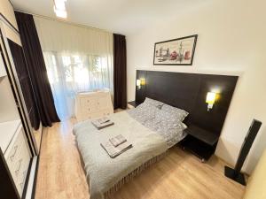 Valea LupuluiにあるERA Apartmentの大きなベッドとタオル2枚のある寝室