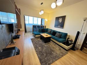 Valea LupuluiにあるERA Apartmentの青いソファとテレビのあるリビングルーム
