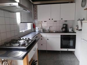 eine Küche mit weißen Schränken und einem Herd mit Backofen in der Unterkunft Holiday home in Sint Maartenszee in Sint Maartenszee