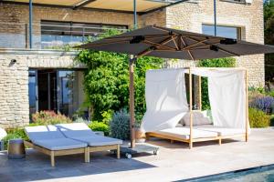 un patio con dos sillas y una sombrilla en 8-bedroom luxury villa with pool, en Gordes