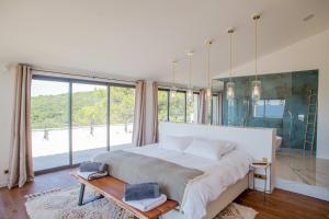 Un dormitorio con una cama grande y una ventana grande. en 8-bedroom luxury villa with pool, en Gordes