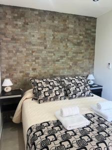 a bedroom with a bed with black and white pillows at Cabañas del Fuego in Potrero de los Funes