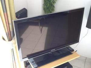 a large flat screen tv sitting on a table at bungalow for 6 people, near the beach in Sint Maartenszee