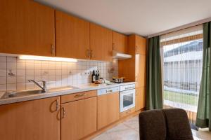 a kitchen with wooden cabinets and a sink and a window at Haus Kaufmann in Ellmau
