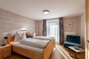 a bedroom with a bed and a blue chair at Haus Kaufmann in Ellmau