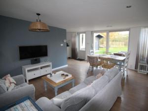 a living room with a couch and a table at Furnished bungalow near beach in Sint Maartenszee