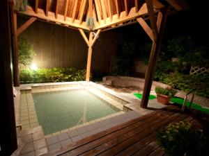 een zwembad onder een prieel 's nachts bij Hotel Folkloro Hanamakitowa in Hanamaki