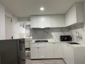 博卡拉Ashish Service Apartment - S3的厨房配有白色橱柜和黑色冰箱