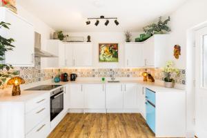 GloucestershireにあるQueens Head Apartmentsの白いキャビネットとウッドフロアのキッチン