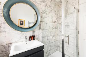 a bathroom with a sink and a mirror at Queens Head Boutique Hotel Apartments in Gloucestershire +13 photos
