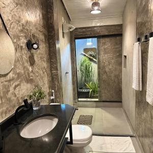 a bathroom with a sink and a toilet at Jardim Secreto Guest House in Búzios