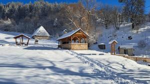 a gazebo in the snow next to a fence at Vikend kuce i odmaraliste JuliE etno - Sarajevo Jahorina in Tvrdimići