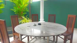 un tavolo in legno con sedie e un tavolo con una tazza sopra di Beach side villa a Bentota