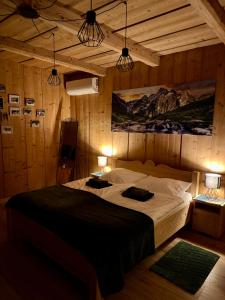 a bedroom with a large bed in a room with wooden walls at Apartamenty u Gąsiorów in Biały Dunajec