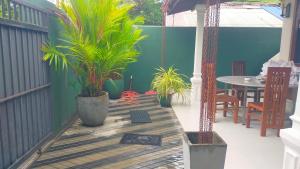 un patio con palme, tavolo e sedie di Beach side villa a Bentota