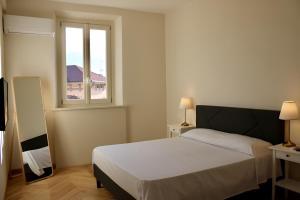 a bedroom with a white bed and a window at Casa Rebei Menaggio in Menaggio