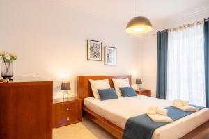 a bedroom with a large bed with blue pillows at Altura Vacations V3, Algarve in Altura