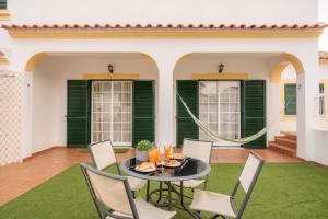 a patio with a table and chairs and green shutters at Altura Vacations V3, Algarve in Altura
