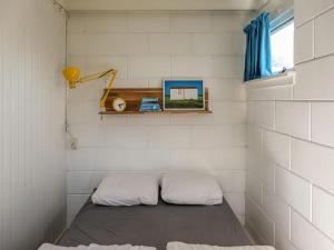 a small room with a bed and a window at Family bungalow with garden in Sint Maartenszee